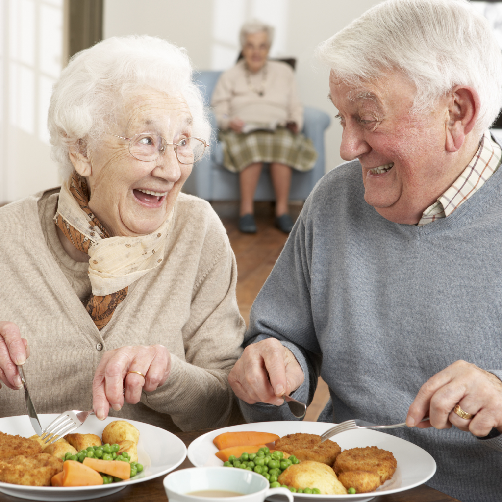 Two seniors enjoying food together.